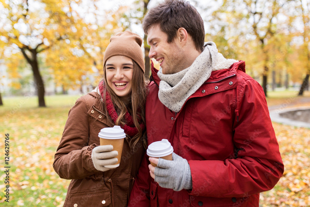 happy couple with coffee walking in autumn park
