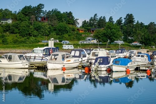 Nordic fishing boats moored at calm lake shore photo