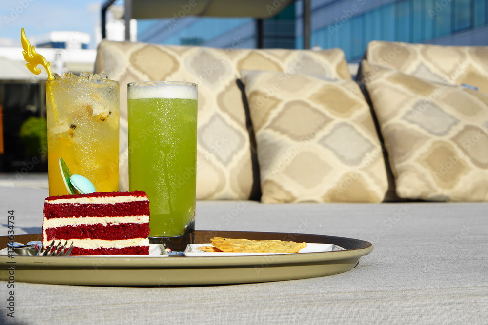 cocktail with red velvet cake and snack serve at outdoor bed - evening sunlight with select and soft focus