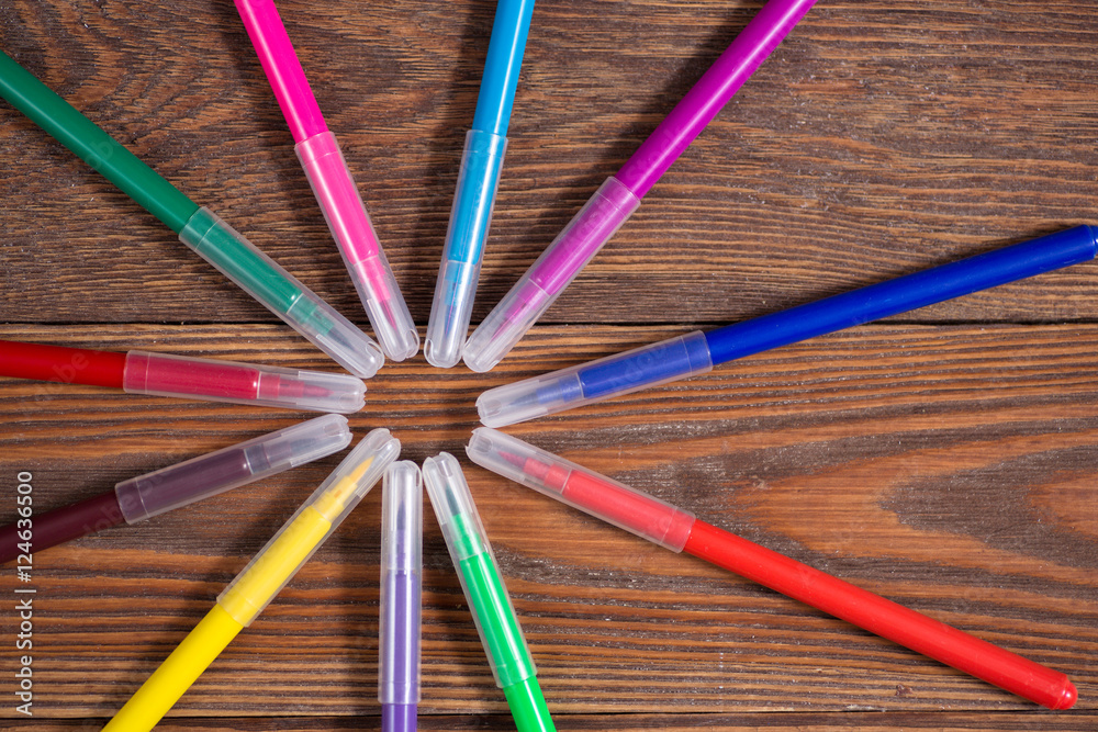 Fototapeta premium colored felt-tip pens on a wooden table background, the concept