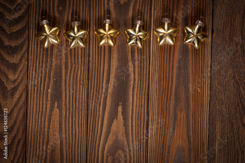 Christmas toys golden stars on wooden background concept Chris