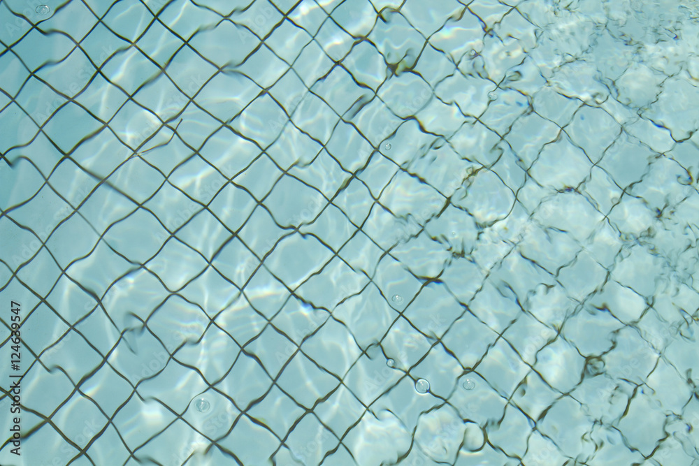 Fototapeta premium Swimming pool floor with light blue water and black grid between