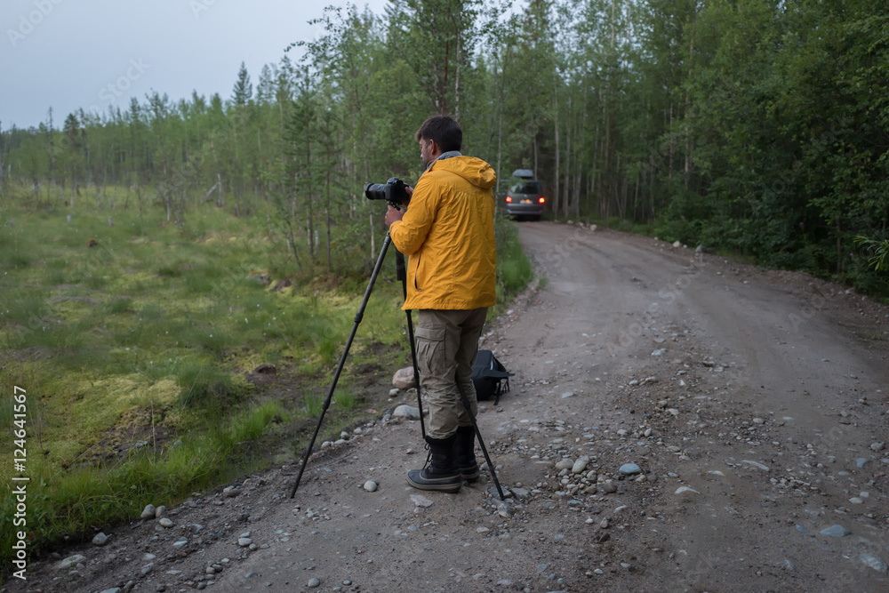 Photografer is making photos on the forest road Photografer is making photos on the forest road