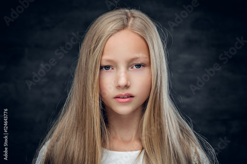 Studio portrait of blonde teenage girl on grey background.