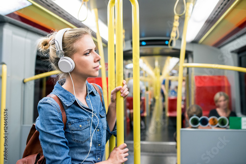 Photography Beautiful young woman with headphones in subway train