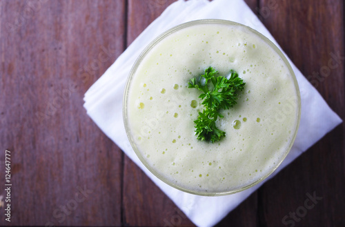 Top view of a glass of melon with yogurt smoothie on a wooden table.