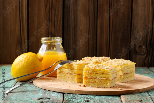 Homemade yummy lemon cake with lemon curd on shabby wooden backg
