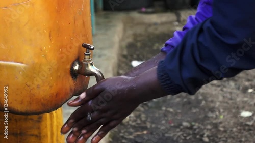 Close up of african people washing hands in water from a tap