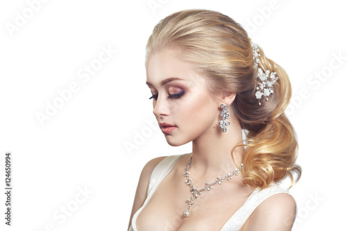 Beauty portrait of a cute blonde gorgeous bride with a beautiful hairstyle in jewelry.