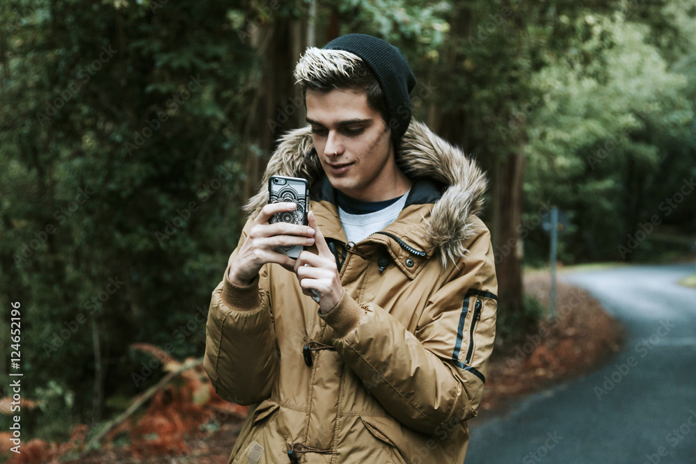 Obraz premium boy with mobile phone in the forest
