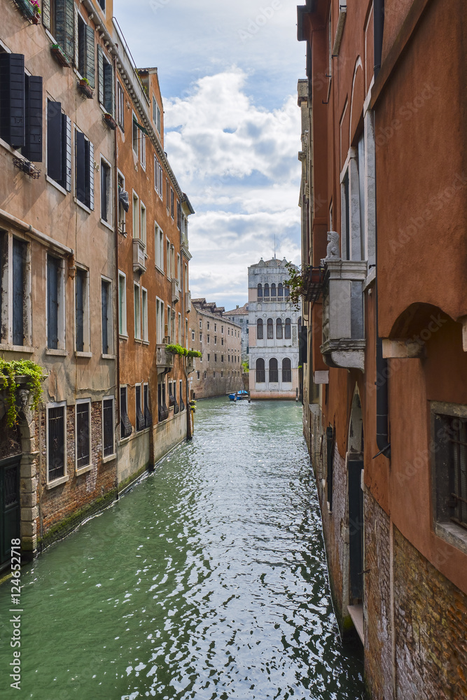 Venice cityscape. Narrow canal among old colorful brick houses in Venice, Italy.