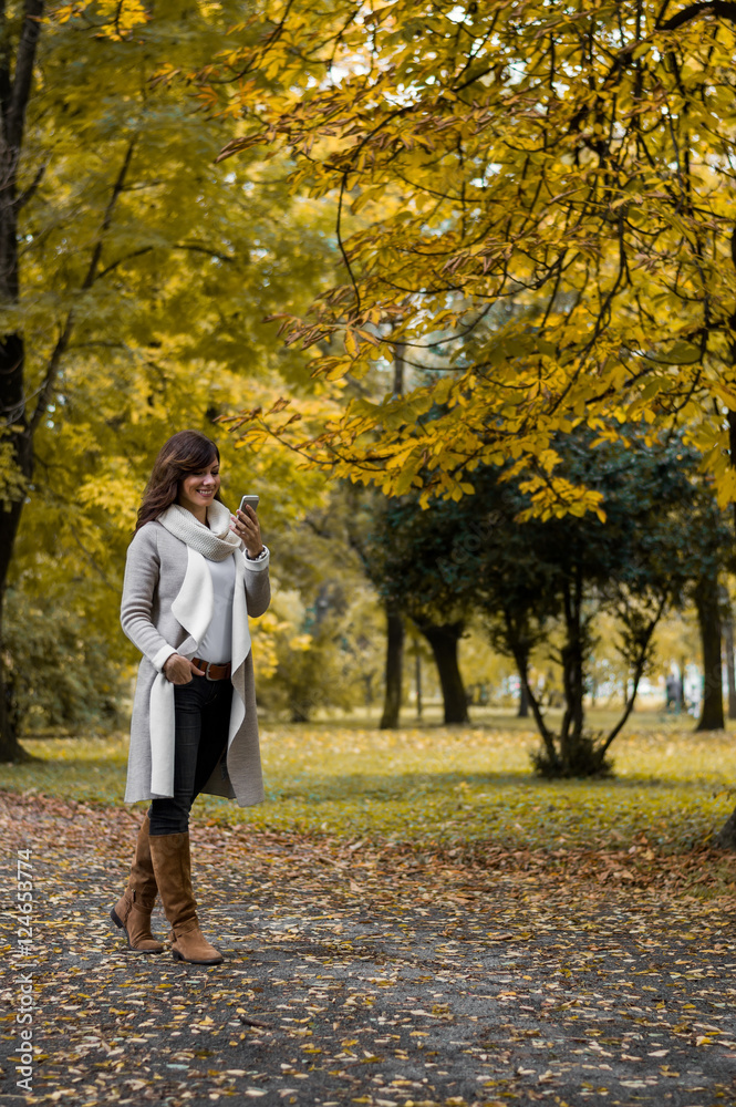 Woman in autumn park talking on smartphone Woman in autumn park talking on smartphone