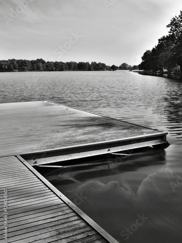 black and white photo of wooden pier on Alum Lake 'Kamencove jezero' in Chomutov city at the end of the summer tourist season photo