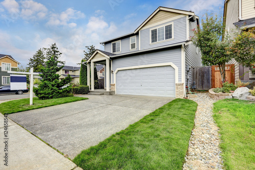 Exterior of large blue house with garage and column porch. © Iriana Shiyan