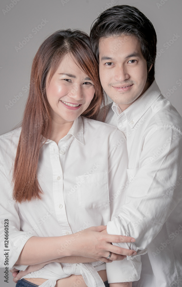 Smiling young couple embracing and standing full length on Cream background,Beautiful loving couple hugging kiss and having fun. Happy Couple in Love Smiling young couple embracing and standing full length on Cream background,Beautiful loving couple hugging kiss and having fun. Happy Couple in Love