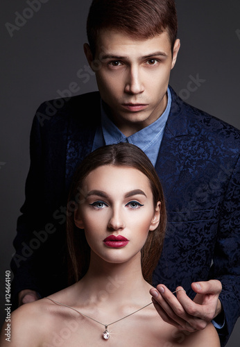 Принти на полотні Glamour fashion couple. Young man man puts on a perl necklace on