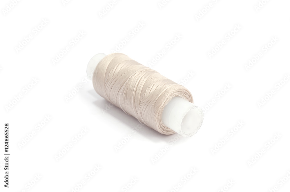 Spools of beige cotton threads on white background Spools of beige cotton threads on white background