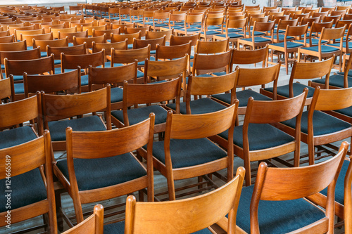 Many Empty Wooden Chairs With Backrest, Blue Upholstery Standing