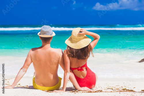 back view of couple sitting on a tropical beach on Mahe  Seychelles