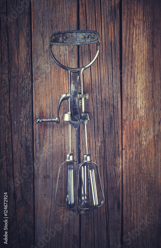 Whisk Beating Eggs on wooden background.Hand mixer.Vintage style.Top view. Space for text.Toned image.
