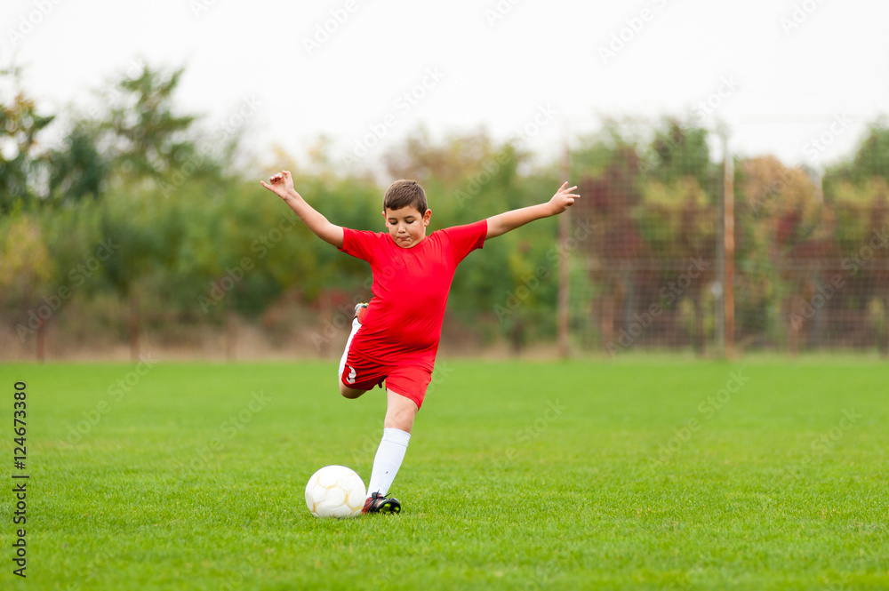 Young chubby soccer player kicking the ball Young chubby soccer player kicking the ball