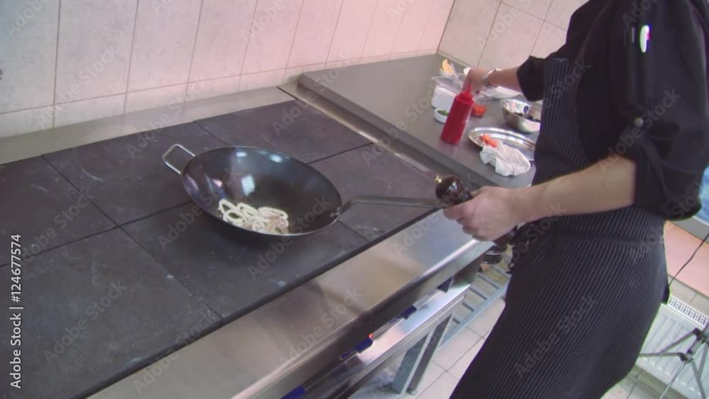 Cook shake wok frying pan on stove, add oil, pepper, salt. Restaurant kitchen. Process of cooking. Steam Cook shake wok frying pan on stove, add oil, pepper, salt. Restaurant kitchen. Process of cooking. Steam