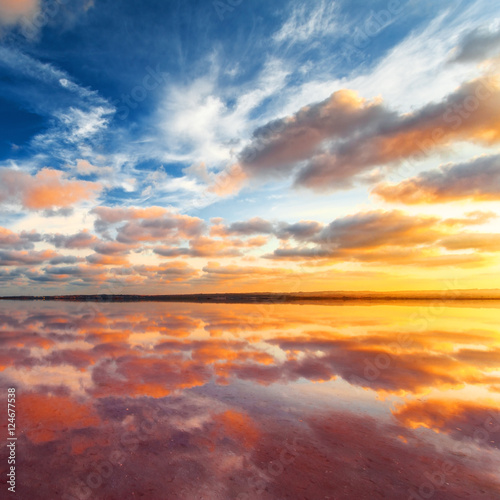 Beautiful sunset landscape. Cloudy sky above salt lake. © Maxim Khytra