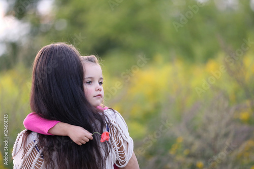 very sad little girl in her mother's arms