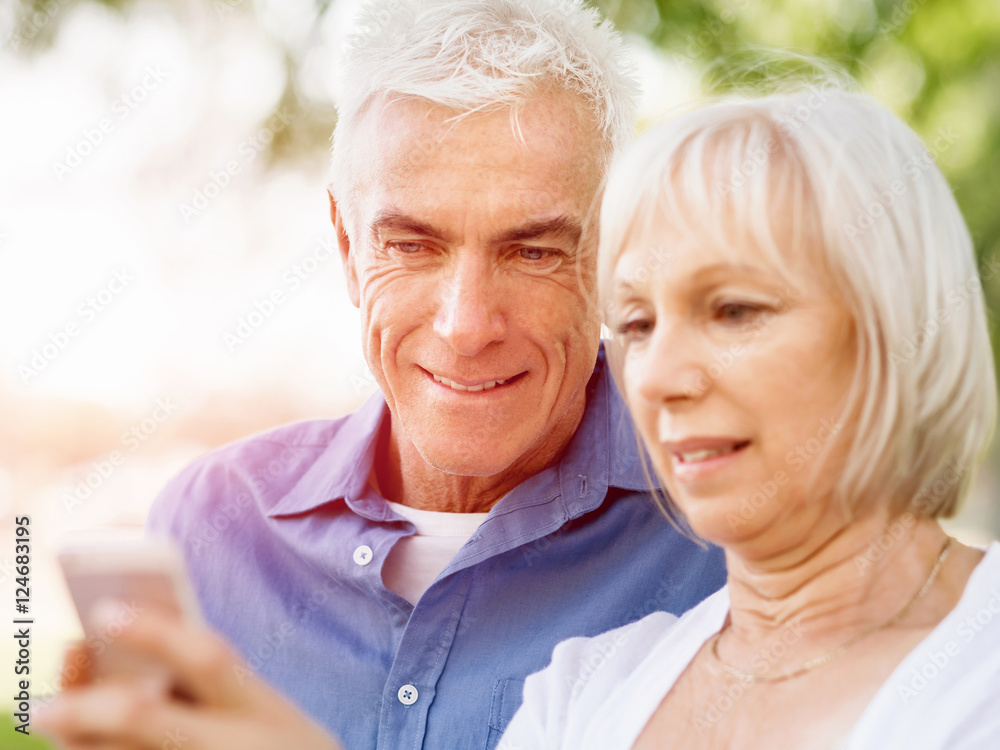 Happy senior couple looking at smartphone Happy senior couple looking at smartphone