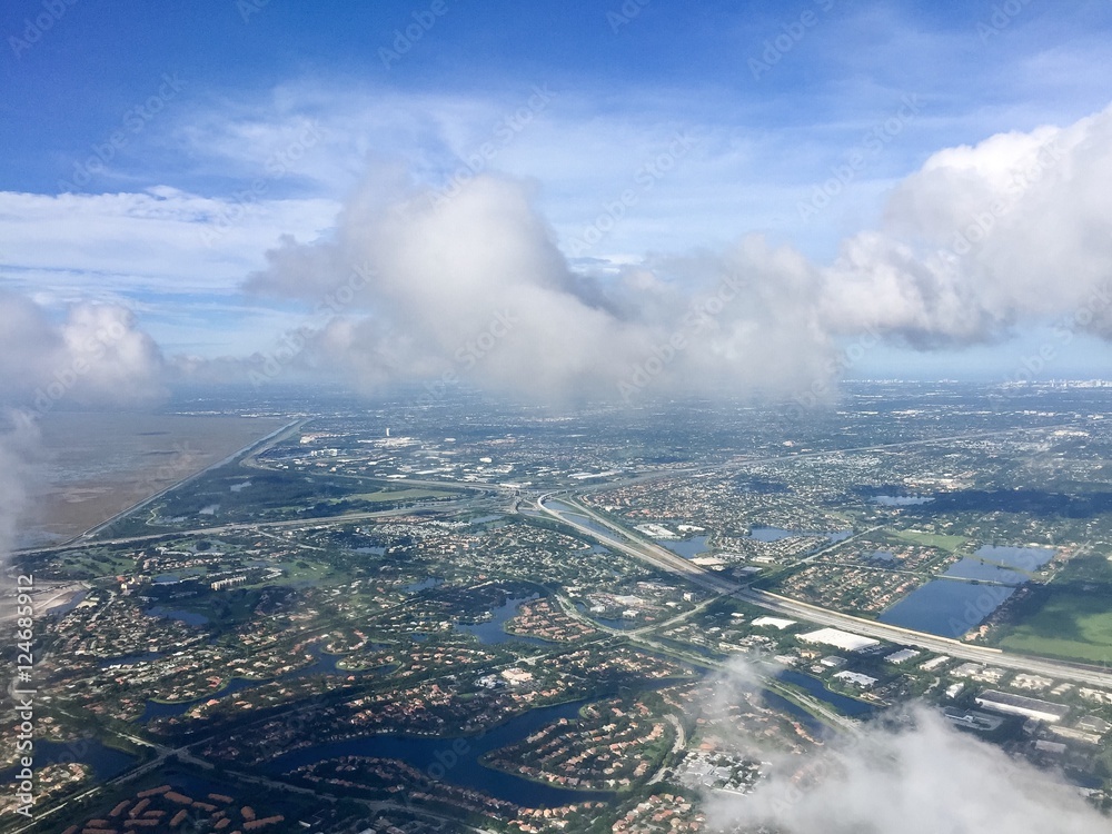 Town, road and river in aerial view from airplane with cloudy sky, Weston, Florida