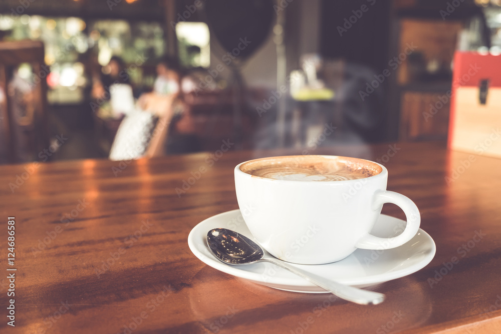 Cup of hot coffee on table in cafe with people. vintage and retro color effect - shallow depth of field