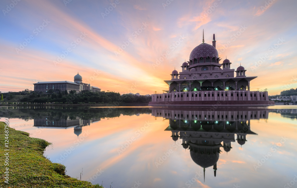 Fototapeta premium View and reflection of Putrajaya Mosque with stunning clouds and sky during sunrise