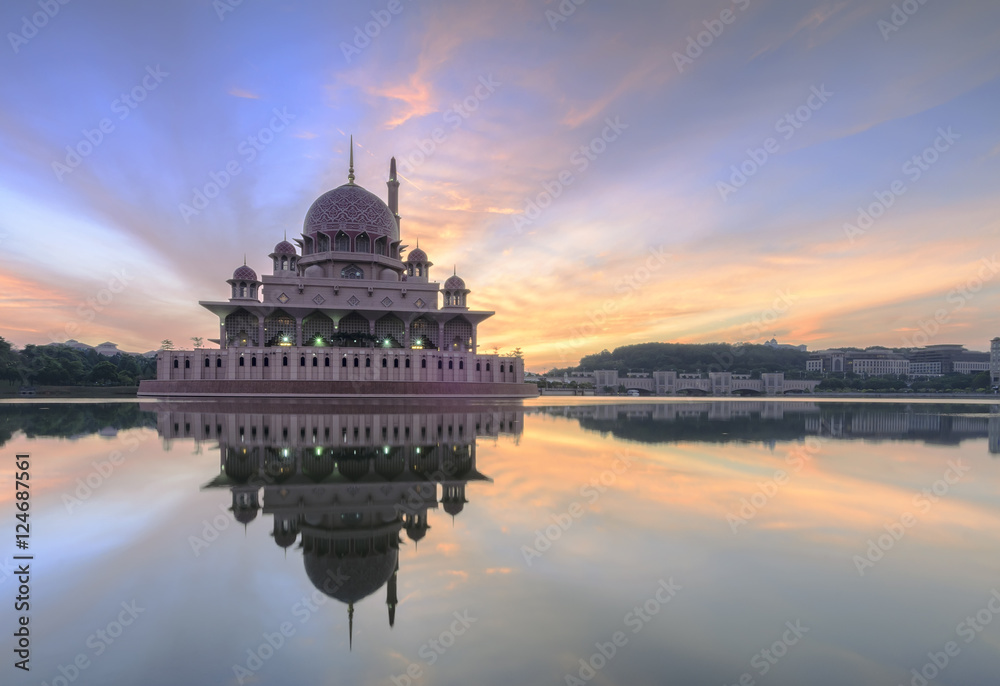 Obraz premium View and reflection of Putrajaya Mosque with stunning clouds and sky during sunrise