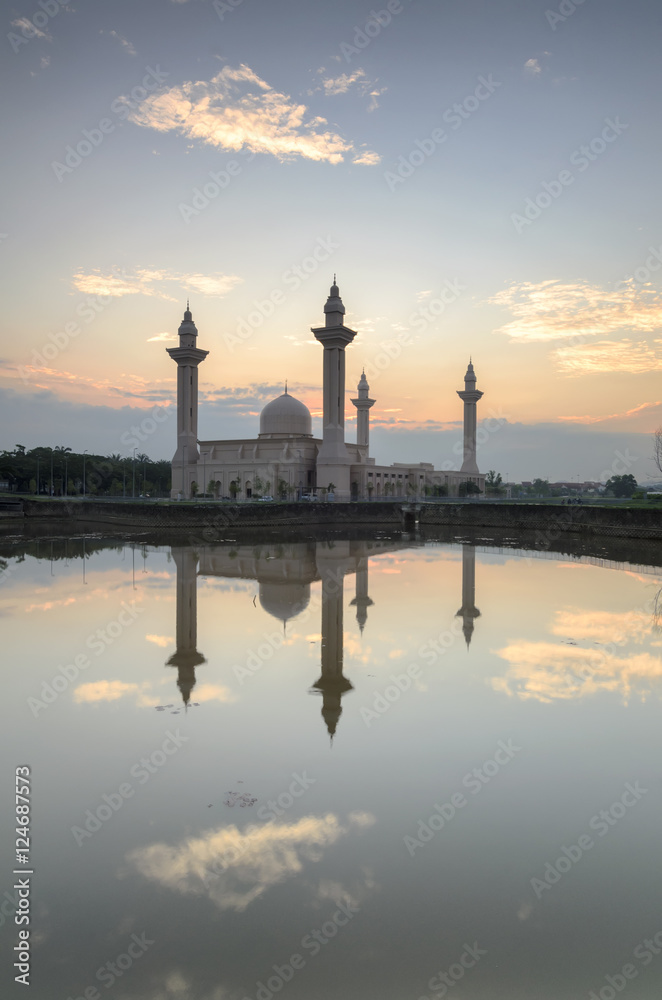 Obraz premium View and reflection of Bukit Jelutong Mosque with purple lotus in the lake during sunrise