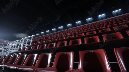 Camera moves among empty bleachers in a basketball arena