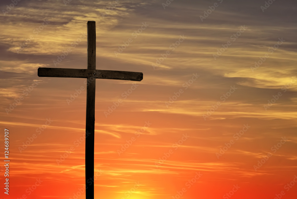 Christian cross over dark red sunset background
