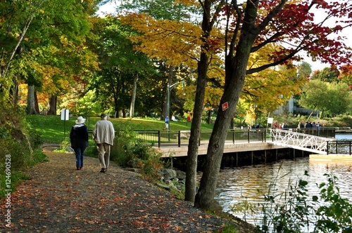 Silhouette of two seniors walking by a lake in fall photo