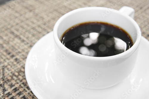 aroma black coffee with bokeh in white cup on the table with spa