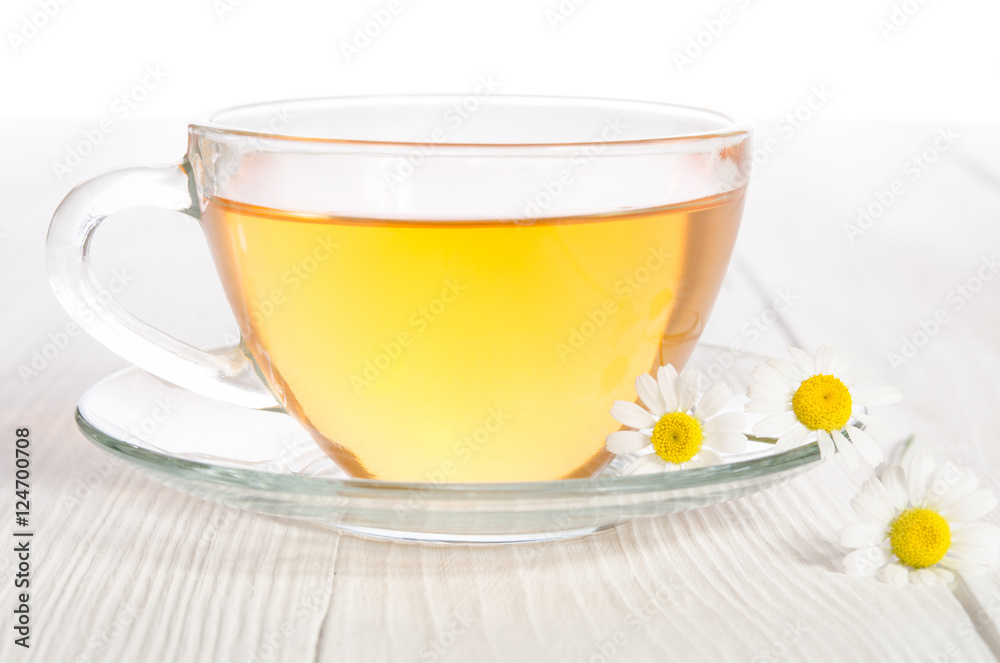 Cup of medicinal chamomile tea on the wooden table Cup of medicinal chamomile tea on the wooden table