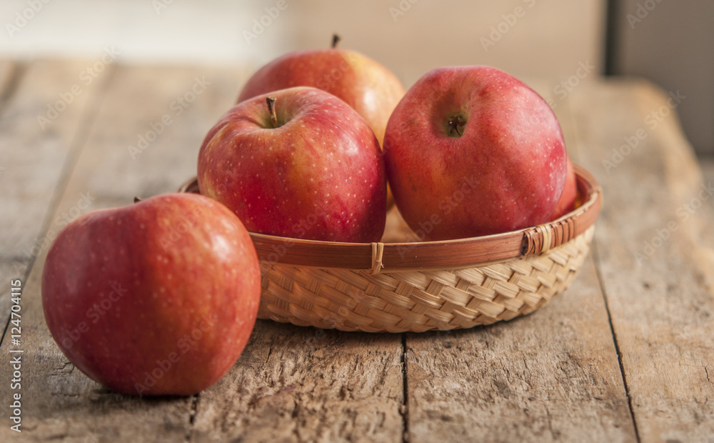 Fresh harvest of apples. Nature theme with red grapes and basket on wooden background. Nature fruit concept. Fresh harvest of apples. Nature theme with red grapes and basket on wooden background. Nature fruit concept.