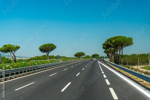 View of the highway with trees and blue sky in Italy