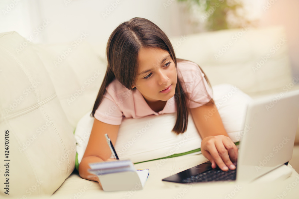 Girl writing in a notebook lying on the bed Girl writing in a notebook lying on the bed