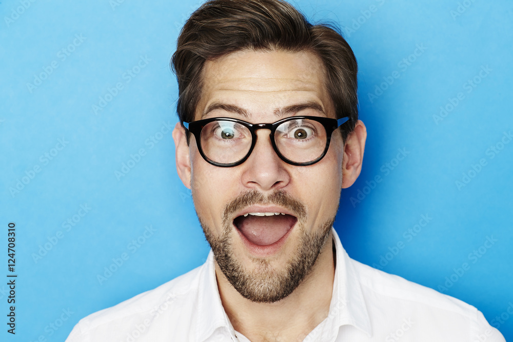 Portrait of surprised guy in blue studio Portrait of surprised guy in blue studio