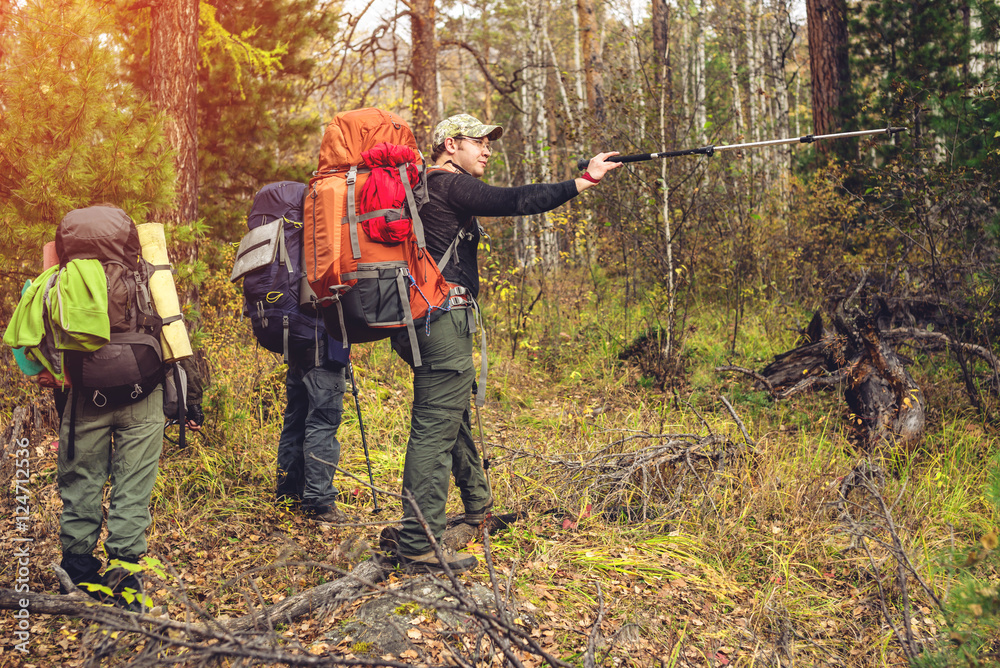 Naklejka premium group of friends with backpacks going up in the forest
