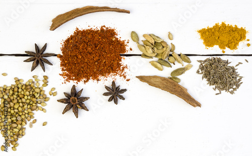 Close up overhead photo of herbs and spices on a white wood deck table photo