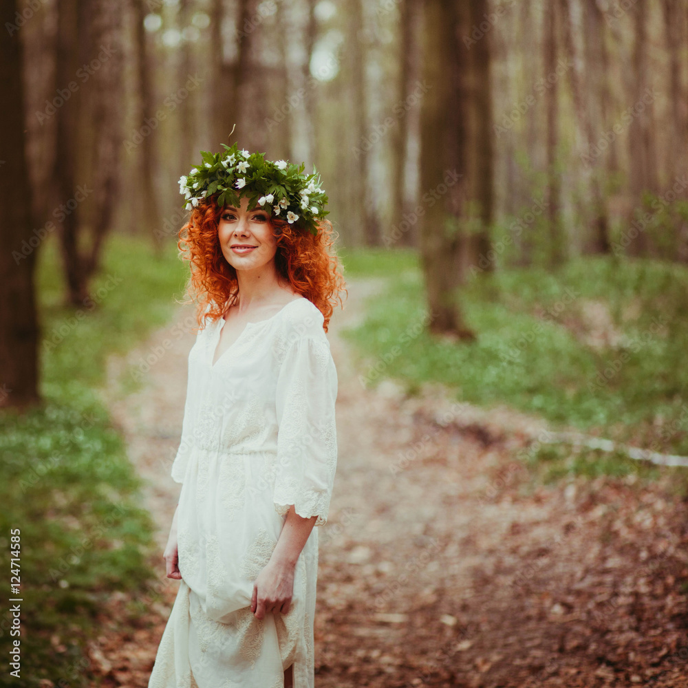 incredibly beautiful red-haired woman in wreath standing in the