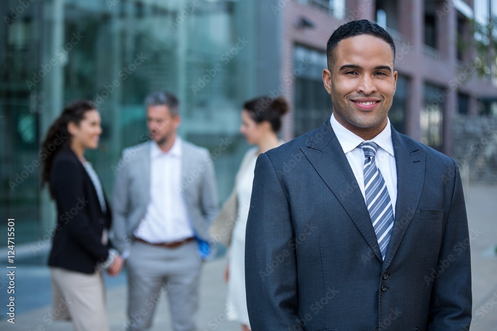 Smiling businessman standing in office building Smiling businessman standing in office building