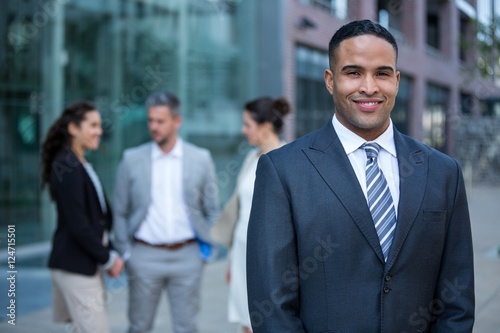Smiling businessman standing in office building
