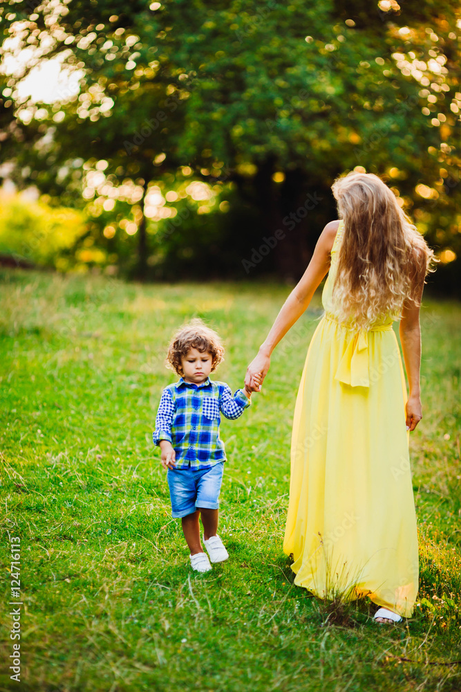Fototapeta premium beautiful young mother with her son walking together in a park