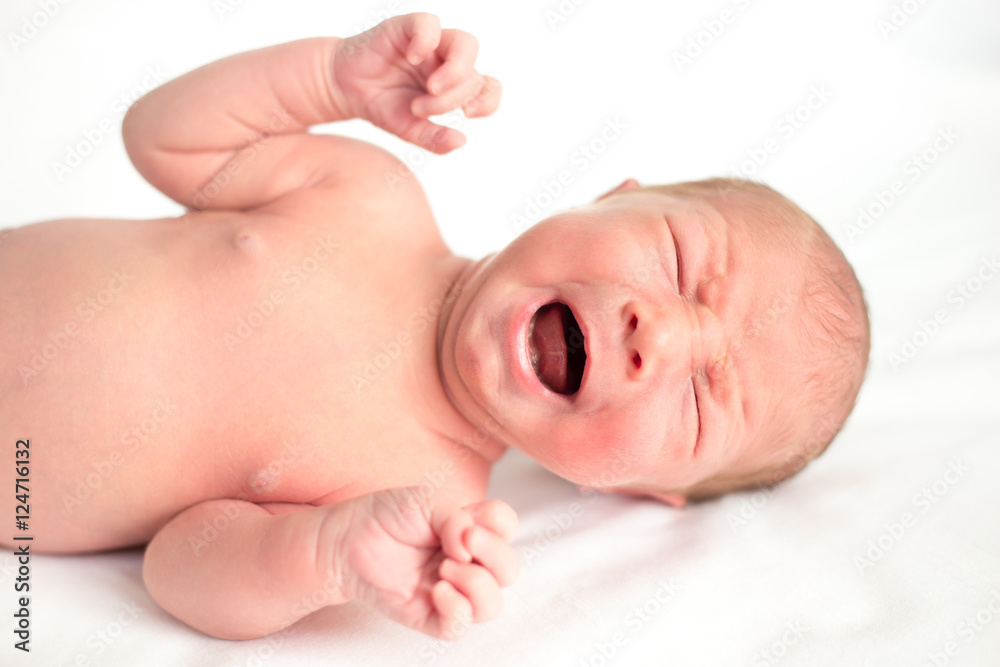 Newborn baby crying. Adorable new born child feeling tired or hungry lying in bed on white blanket. Caucasian infant screaming. Healthy little kid after birth. Close-up portrait Newborn baby crying. Adorable new born child feeling tired or hungry lying in bed on white blanket. Caucasian infant screaming. Healthy little kid after birth. Close-up portrait